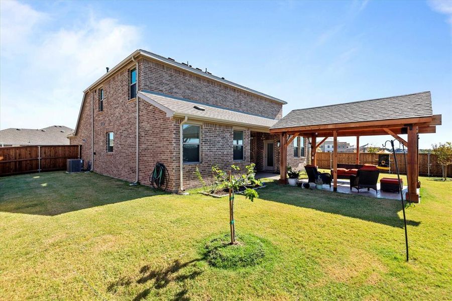 Back of property featuring outdoor lounge area, central air condition unit, a patio area, and a lawn