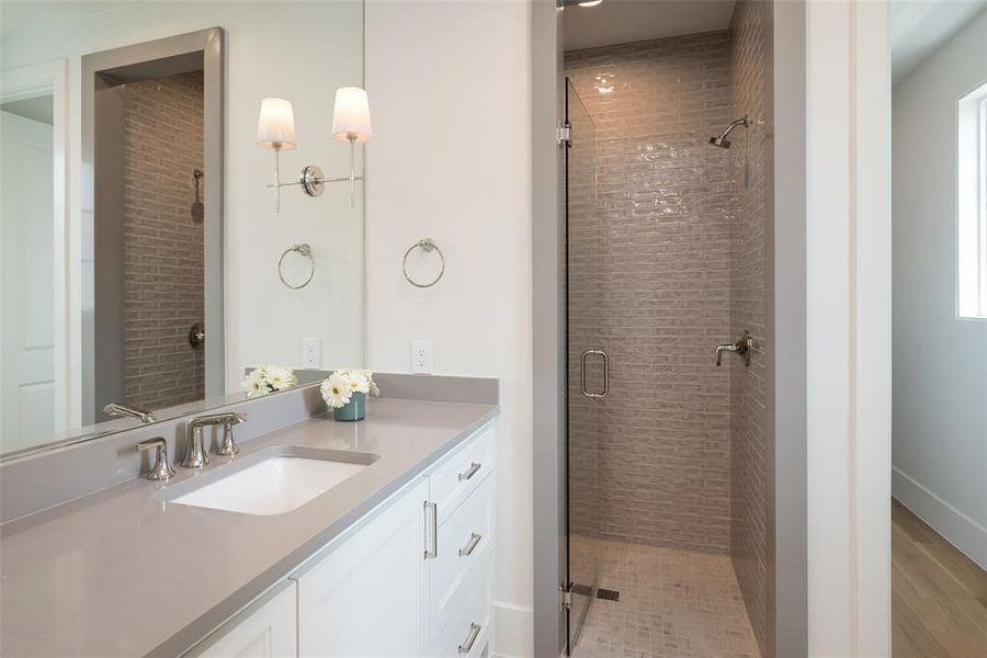 Bathroom featuring an enclosed shower and vanity