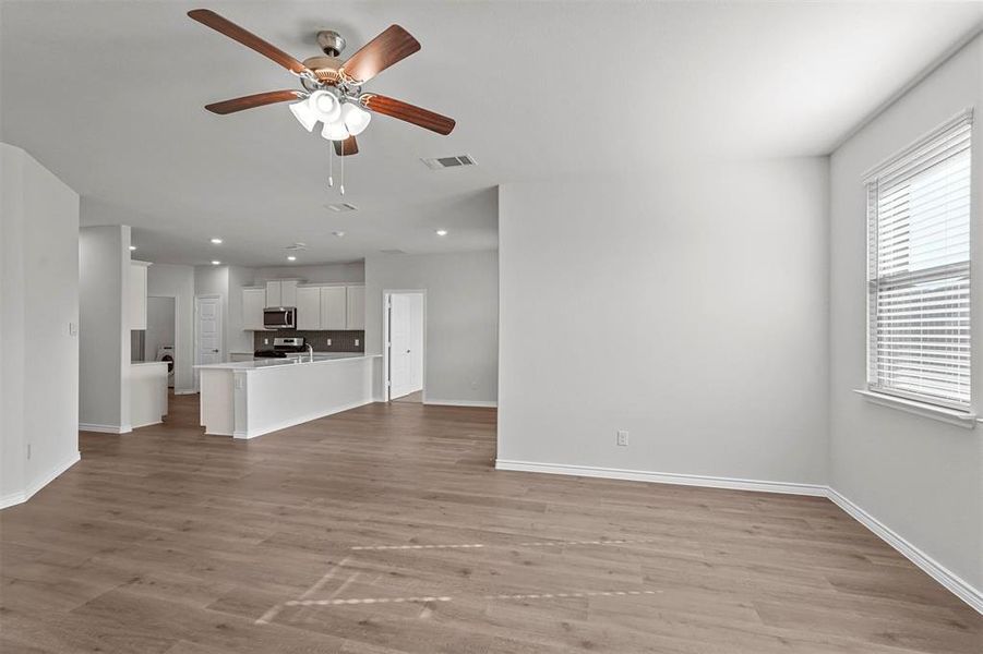 Spacious living room featuring light hardwood / wood-style floors and ceiling fan