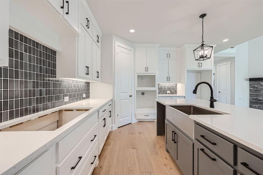 Kitchen featuring white cabinetry, tasteful backsplash, and light wood-type flooring