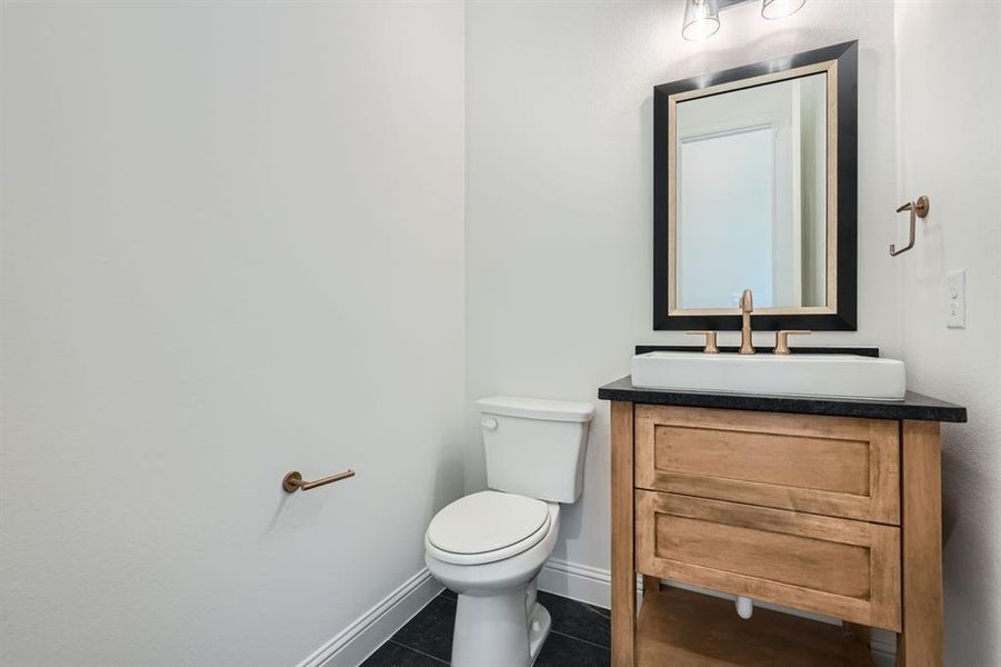 Bathroom featuring tile patterned flooring, toilet, and vanity