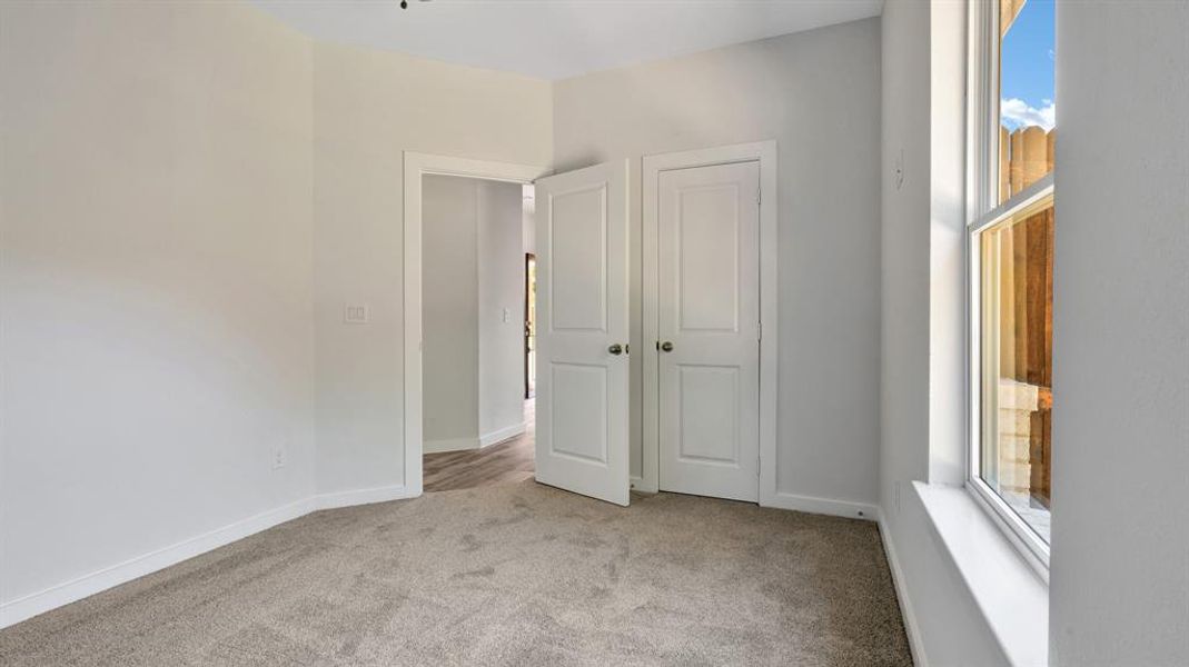 Unfurnished bedroom featuring light carpet