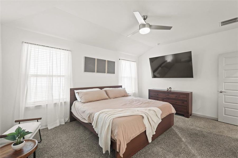 Private spacious primary suite with high ceiling, ceiling fan, and upgraded carpeting