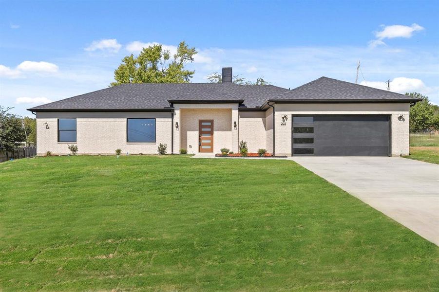 Prairie-style home with a garage and a front lawn