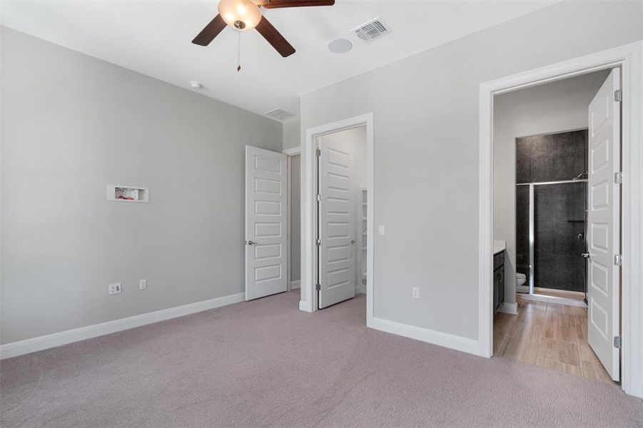 bedroom w/ ceiling fan, walk in closet and private bathroom