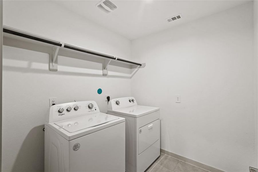 Utility room features a washer and dryer set (included) with ample overhead shelving for storage.