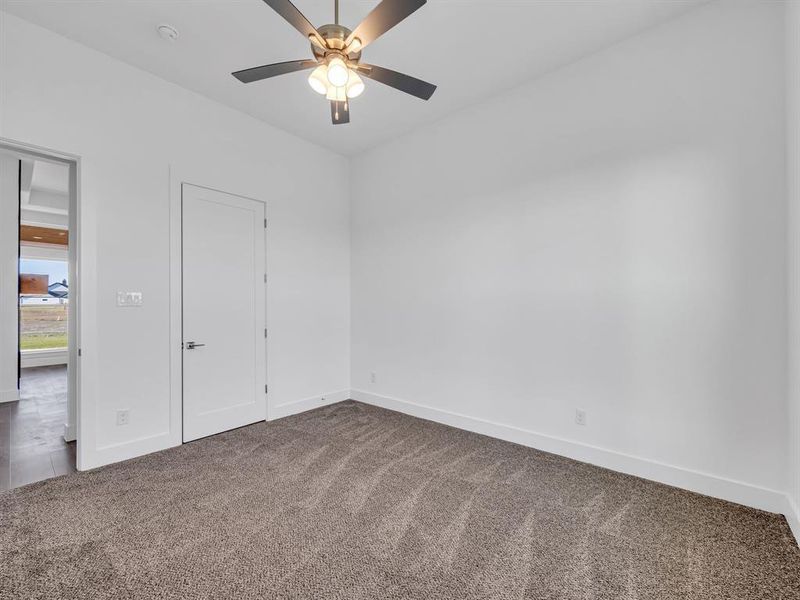 Unfurnished bedroom with ceiling fan and carpet