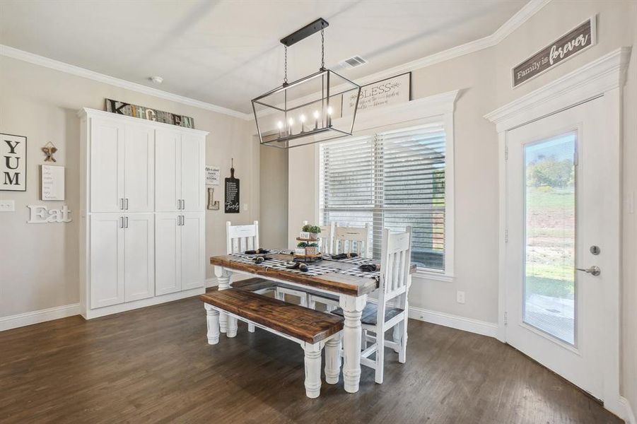 Dining room featuring ornamental molding, dark hardwood / wood-style floors, and a notable chandelier