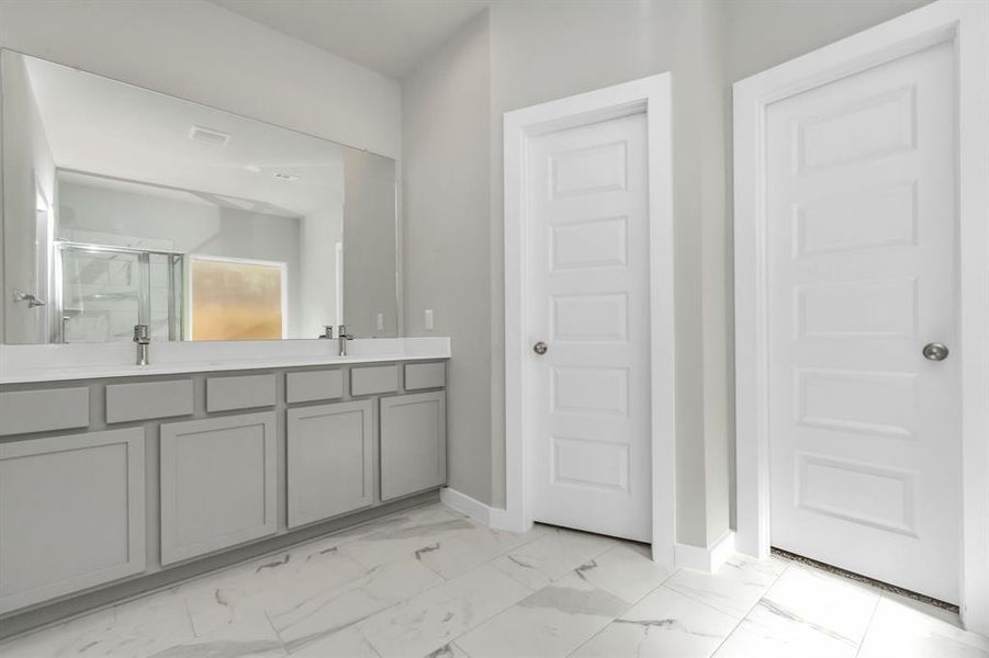 Elevate your daily routine at the elegant vanity, now equipped with double sinks, granite, modern hardware, and recessed lights. Sample photo of completed home with similar floor plan. As built color and selections may vary.