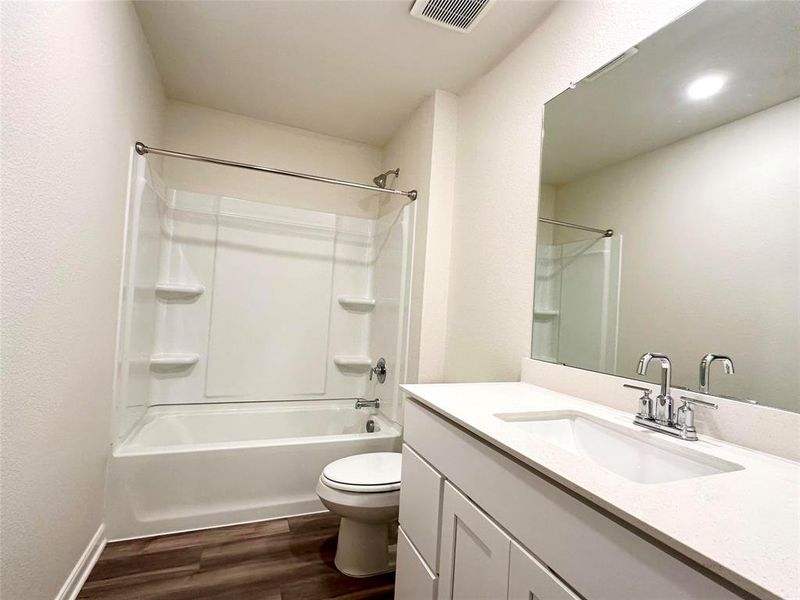 Full bathroom with shower / washtub combination, wood-type flooring, vanity, and toilet