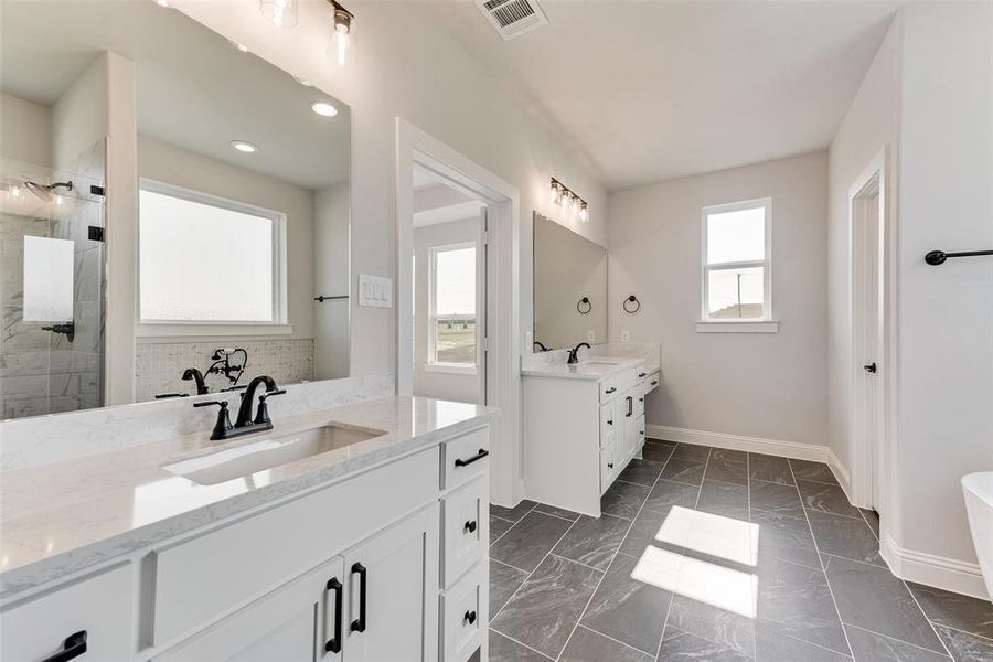 Bathroom with vanity and tiled shower