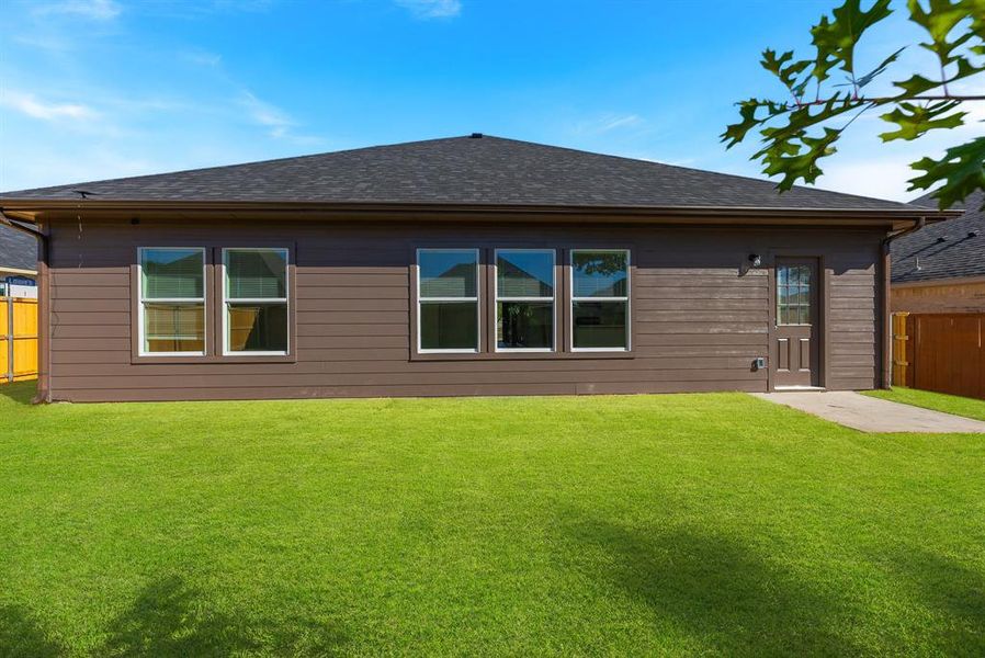 Back of house featuring a lawn and a patio