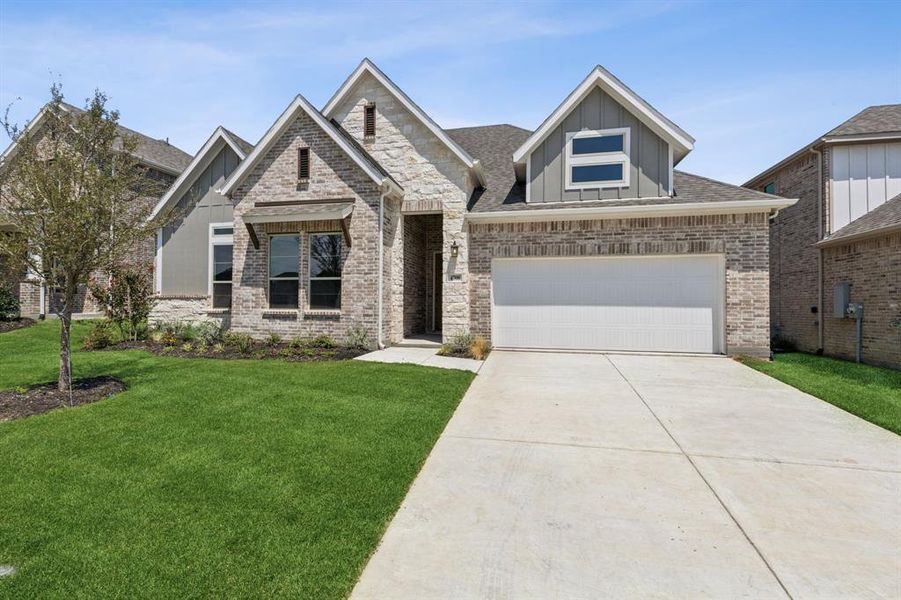 View of front of home featuring a front yard and a garage