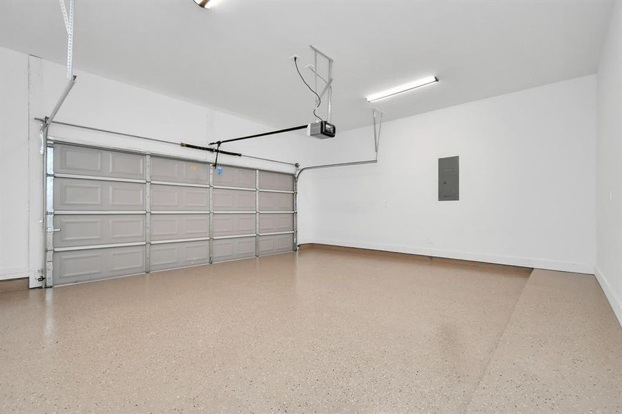 Garage is equipped with durable epoxy flooring and an automatic garage door opener for your convenience. It features overhead lights for ample visibility and easy access to the breaker box.