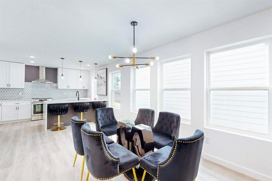 Dining area featuring light wood-type flooring and an inviting chandelier