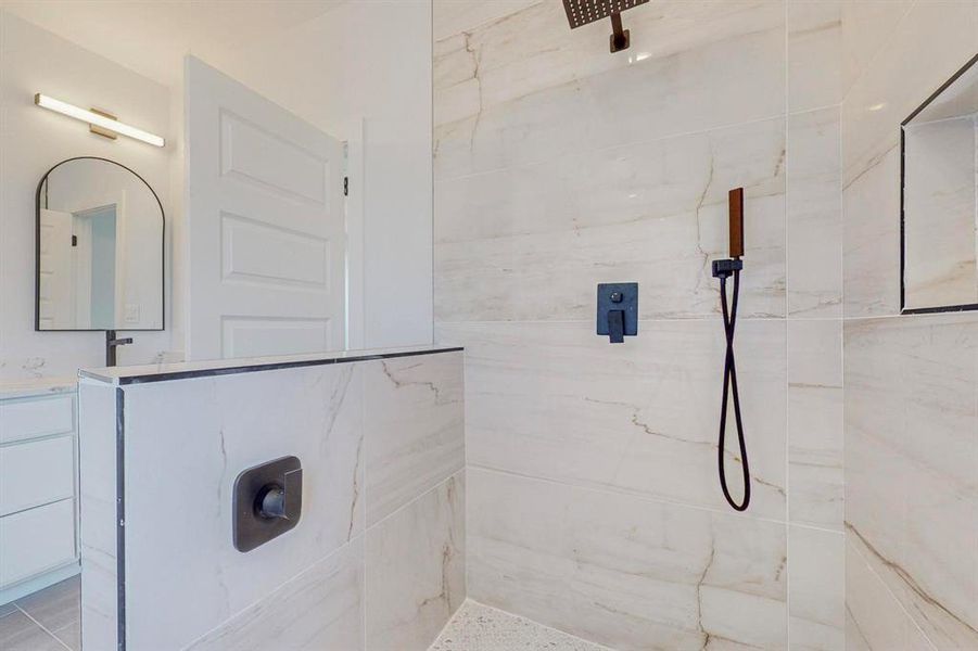 Bathroom featuring vanity and tiled shower