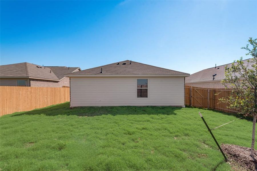 Rear view of property featuring a lawn