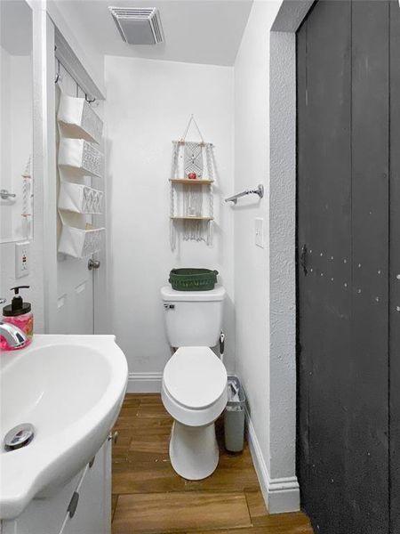 Bathroom featuring toilet, hardwood / wood-style floors, and sink
