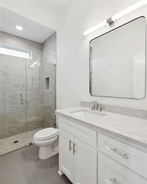 Bathroom with tile patterned flooring, vanity, toilet, and a shower with shower door