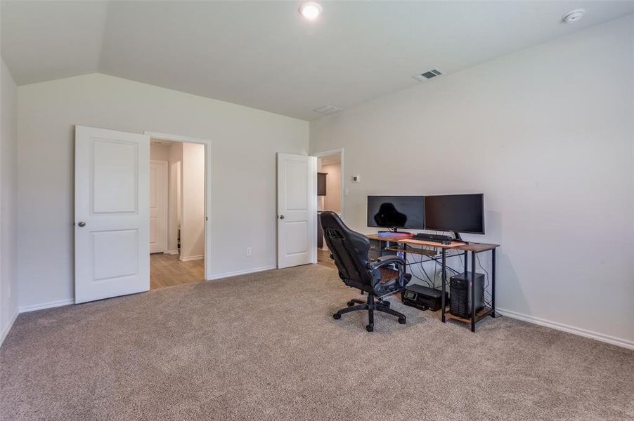 Office space featuring light carpet and lofted ceiling