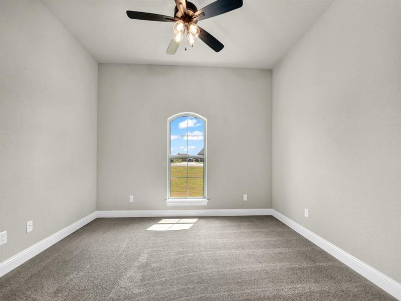 Carpeted empty room with ceiling fan