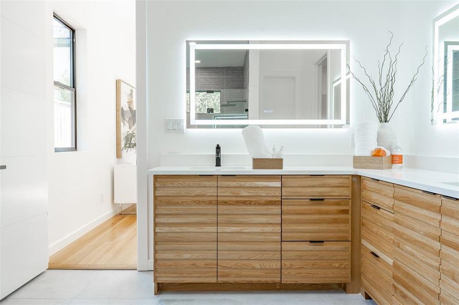 Bathroom with a shower, vanity, and wood-type flooring