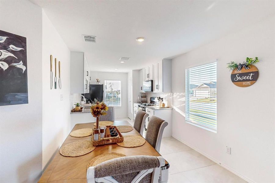 Tiled dining area with plenty of natural light and sink