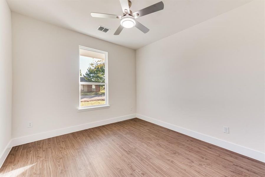 Spare room with light wood-type flooring and ceiling fan