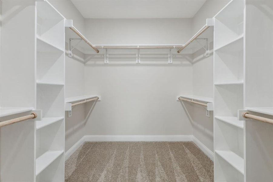 Spacious closet with light colored carpet