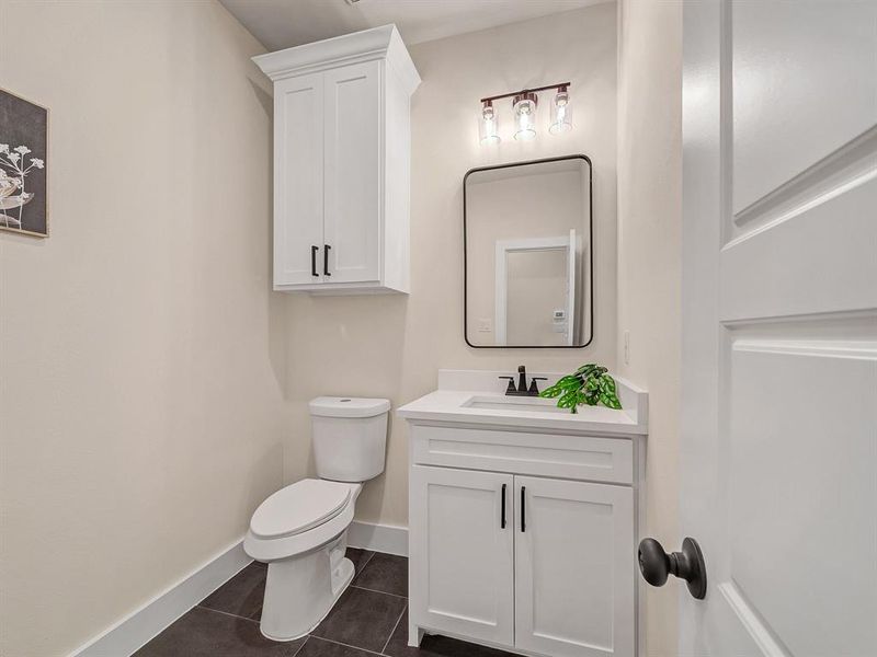 Bathroom with vanity, toilet, and tile patterned floors