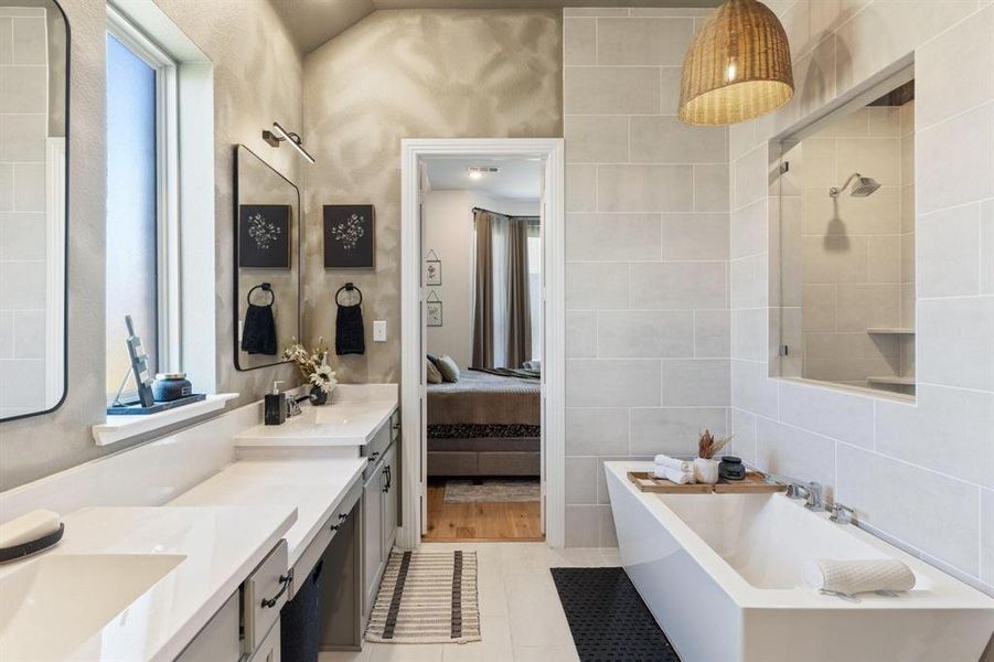 Bathroom featuring tile patterned floors, tile walls, separate shower and tub, and vanity