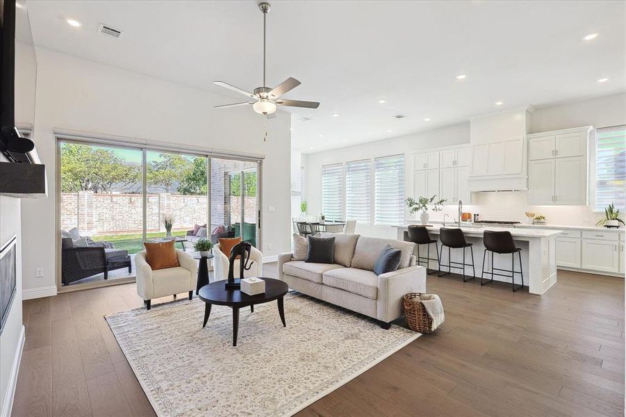 Living room with hardwood / wood-style floors, ceiling fan, and a wealth of natural light