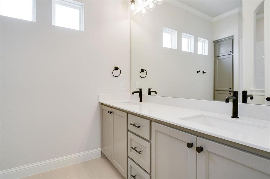 Bathroom with dual vanity, tile patterned flooring, and ornamental molding