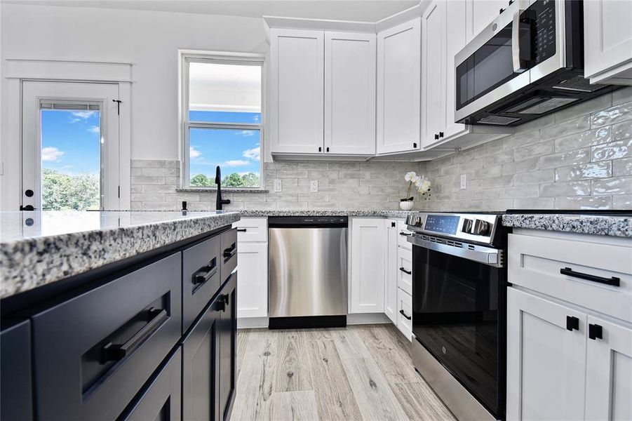 Closeup of the kitchen showing granite counter tops, soft close drawers, stainless steel appliances