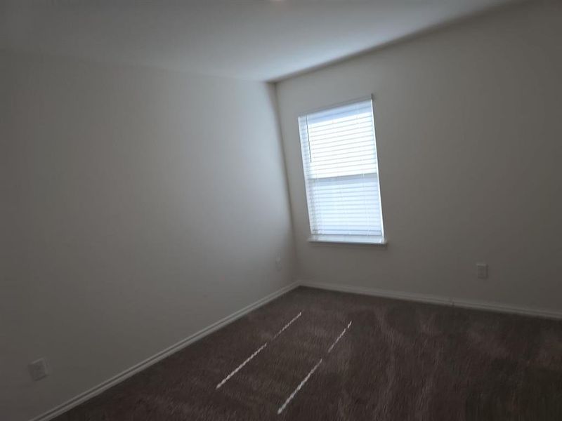 Spare room featuring dark colored carpet