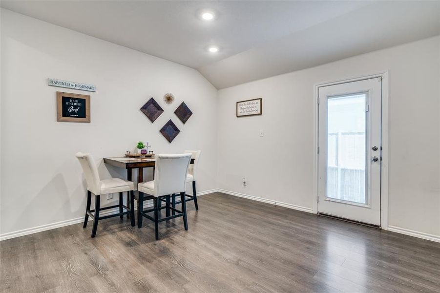 Dining space featuring dark hardwood / wood-style floors and vaulted ceiling