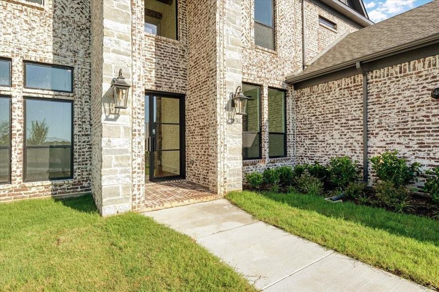 View of exterior entry with a lawn