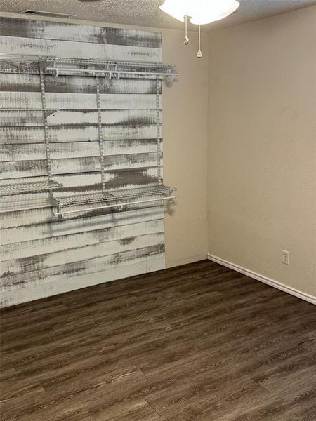 Spare room featuring a textured ceiling and dark hardwood / wood-style floors