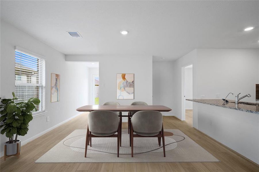 This lovely breakfast/dining area is perfect for starting the day out on the right foot!  This space showcases custom paint, high ceilings, recessed lighting, large window adding to the ample natural light in the kitchen, and vinyl plank flooring!