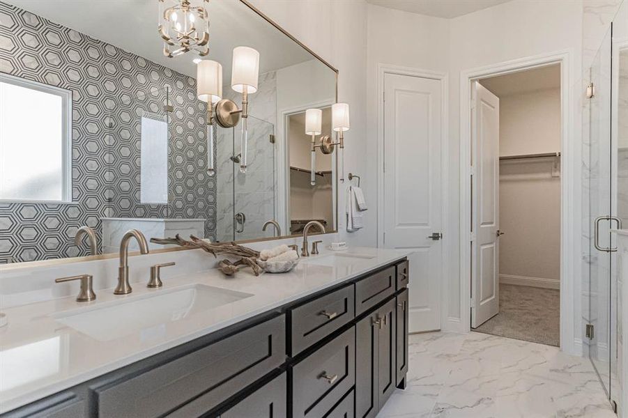 Bathroom with an inviting chandelier, dual sinks, tile flooring, a shower with door, and large vanity