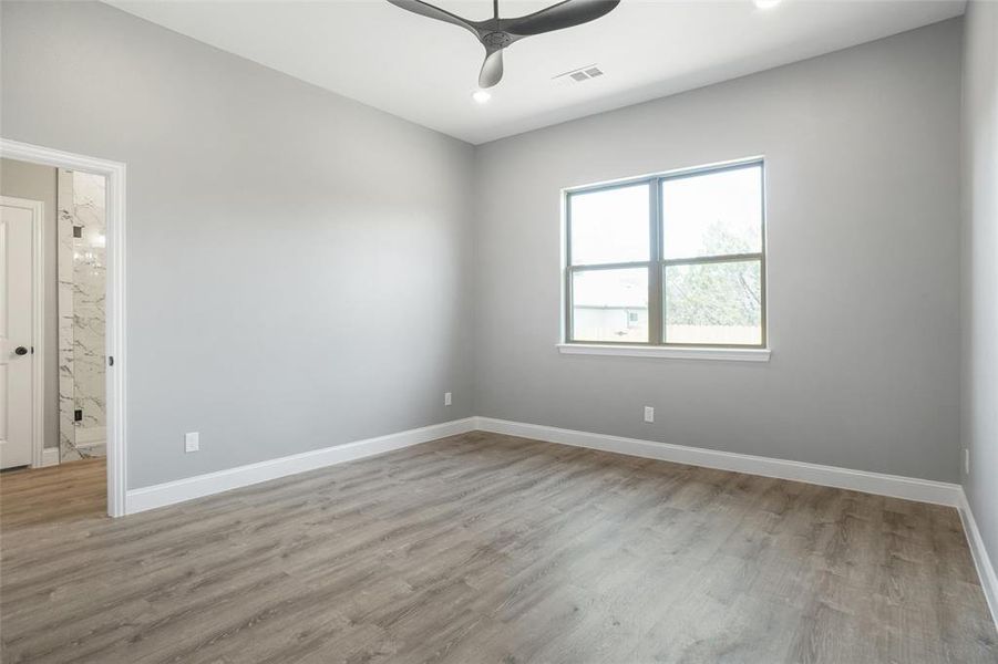 Empty room featuring hardwood / wood-style flooring and ceiling fan