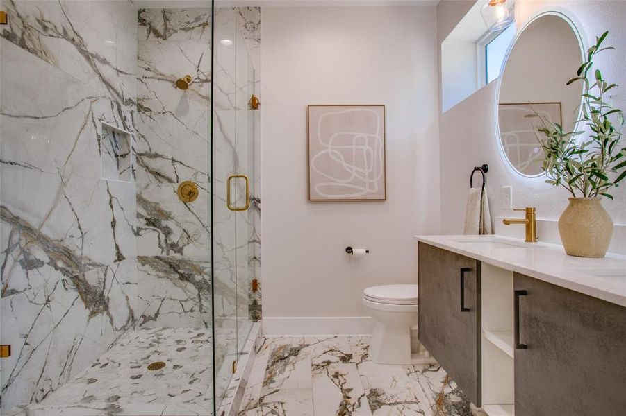 Bathroom featuring a shower with shower door, vanity, tile patterned flooring, and toilet