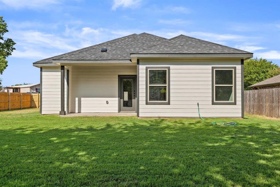 Rear view of house featuring a yard