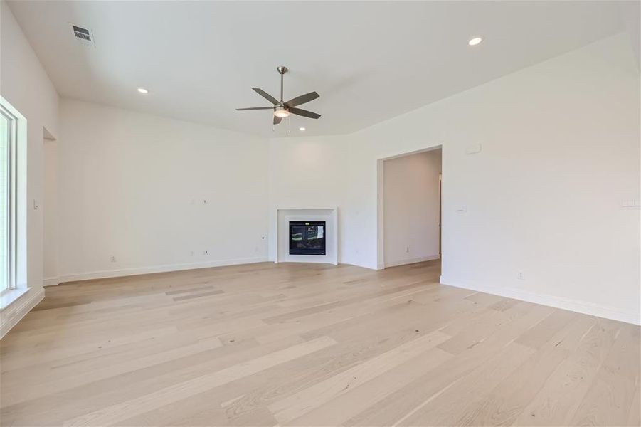 Unfurnished living room with ceiling fan and light hardwood / wood-style floors