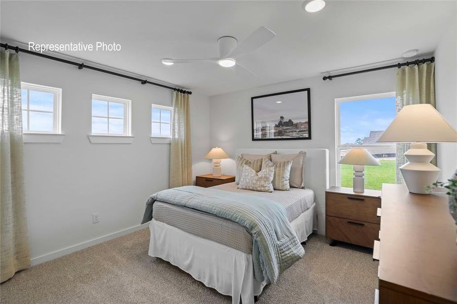 Bedroom with multiple windows, ceiling fan, and light carpet