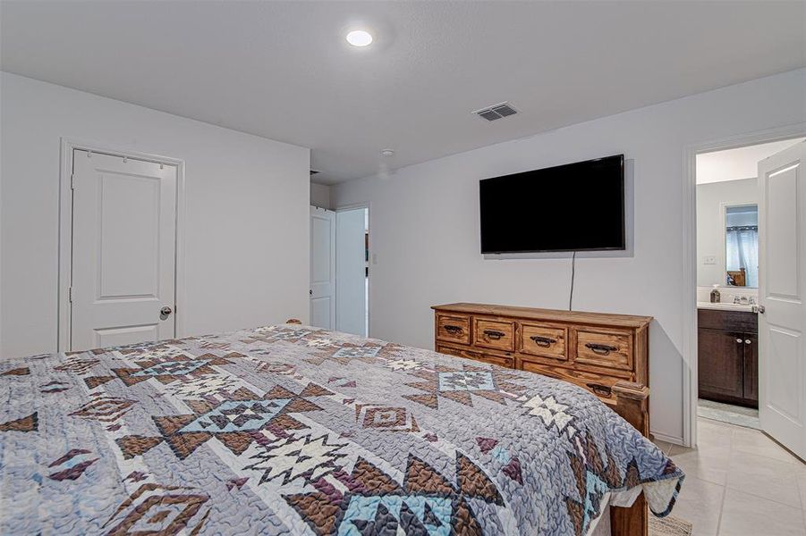 Tiled bedroom featuring sink and connected bathroom