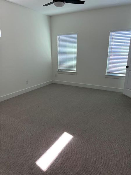 Carpeted spare room with ceiling fan