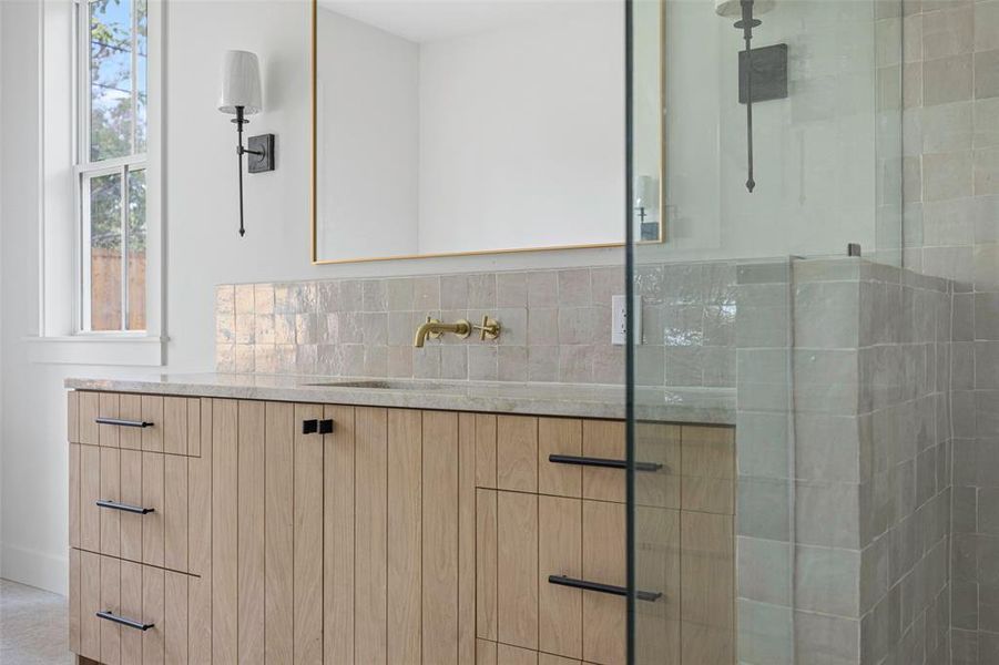 Bathroom with vanity, plenty of natural light, and a shower with shower door