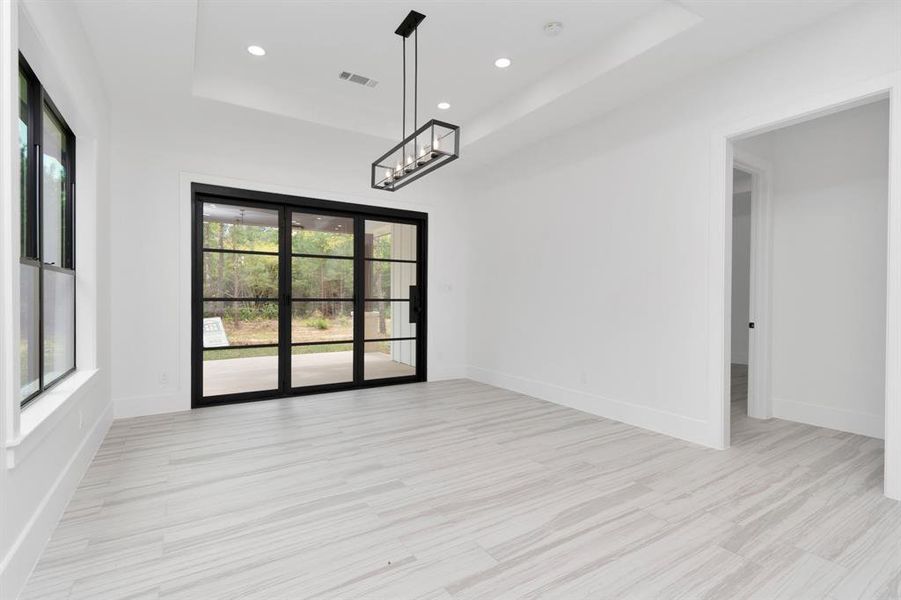 Enjoy seamless indoor-outdoor living with this dining space, featuring elegant sliding doors that invite natural light and views of the outdoors.