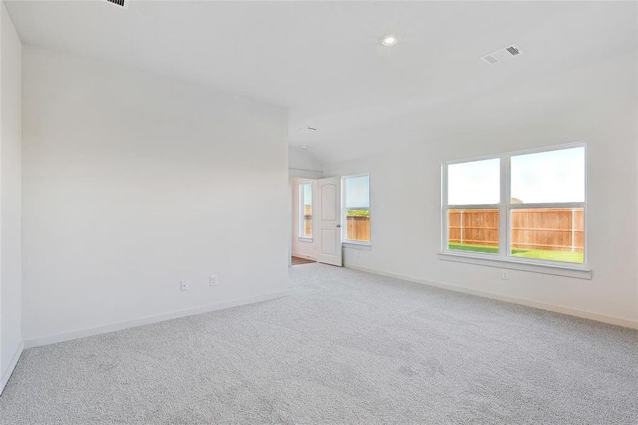 Carpeted spare room with lofted ceiling